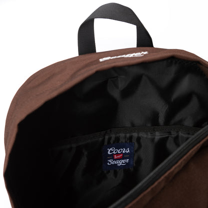 Close-up of backpack interior showing black lining and a Coors Banquet x Seager collaboration label stitched inside.